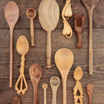 Rustic wooden kitchen utensils over old oak background.